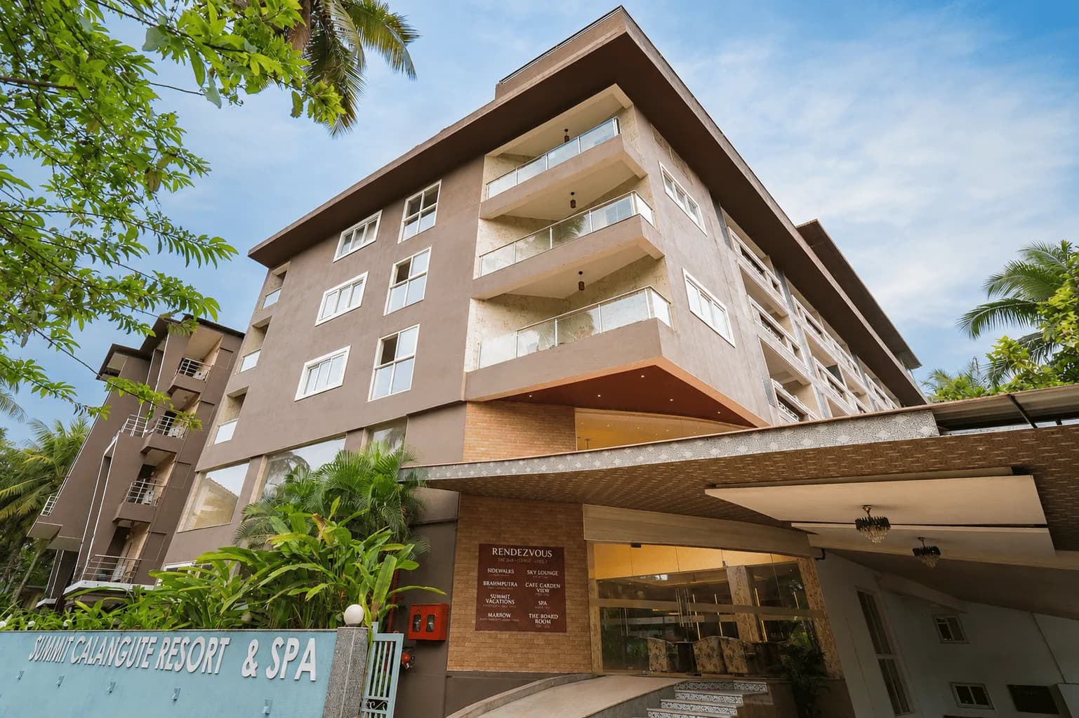 Exterior of Summit Calangute Resort & Spa framed by palm trees